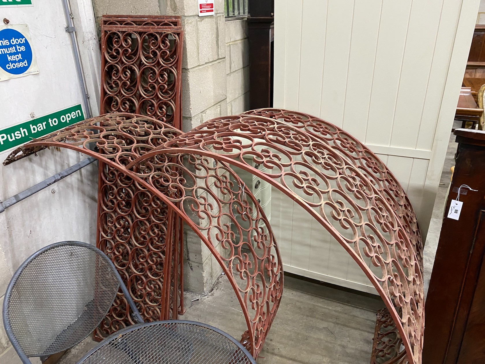 Three red painted wrought iron scrollwork garden arches, width 142cm, height approx. 250cm